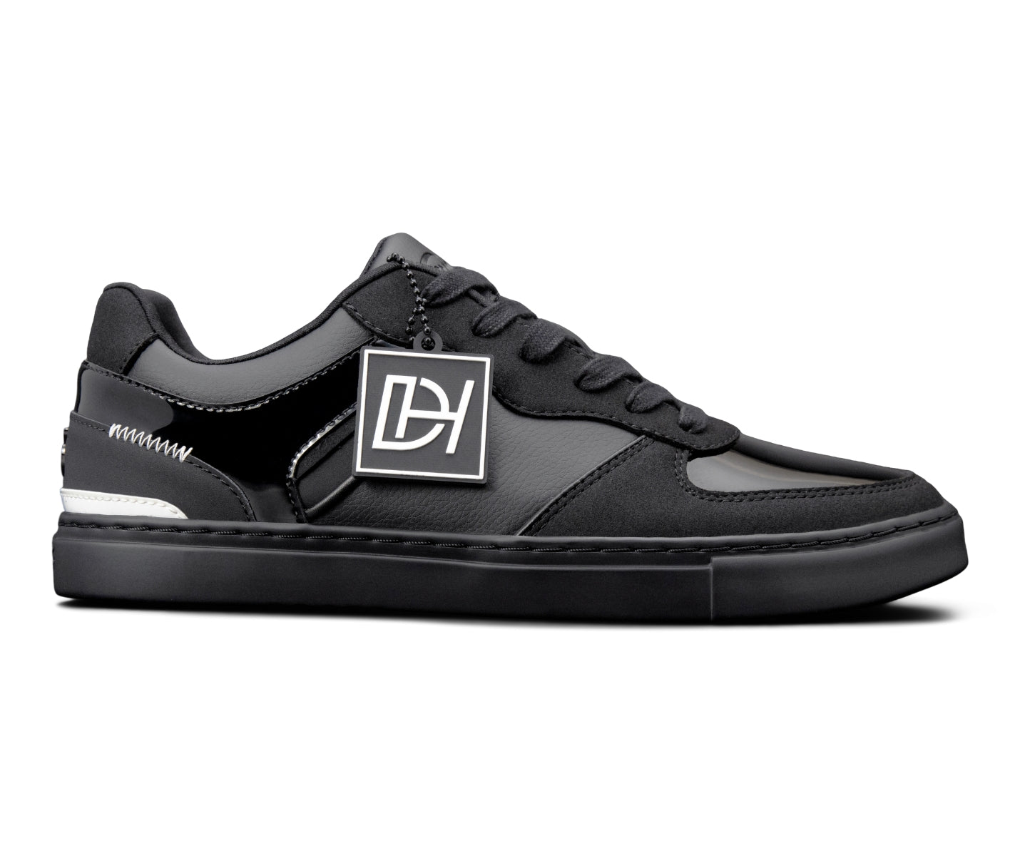 Die Fuego Low-Top Dance Sneakers von Fuego Dance Shoes sind schwarz, vegan, mit weißer Sohle und geometrischem Logo-Tag.
